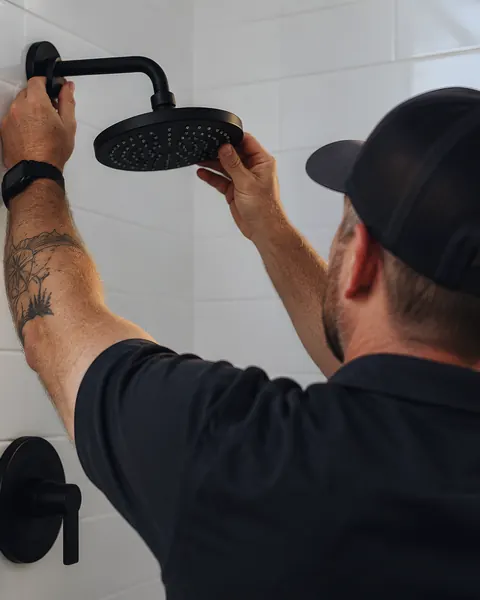 Technician installing shower head: an AI-enhanced reconstruction of American Plumbing Co.’s own photograph.